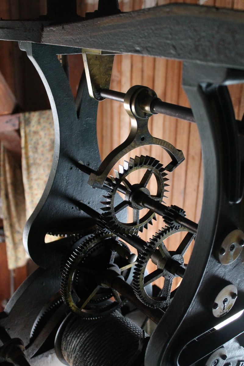 The cast-iron clock movement in the tower, with brass bearings, gear trains and the winding drum below.
